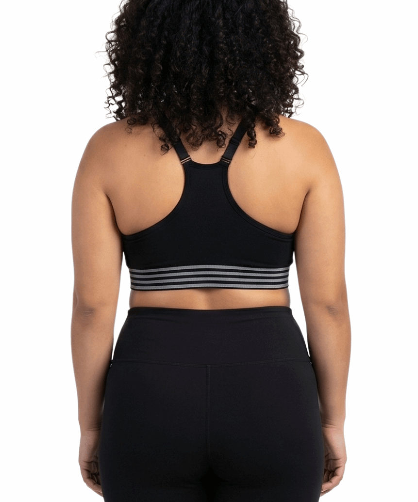 Woman wearing a black sports bra and leggings on a white background