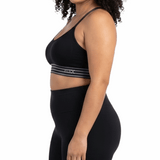 Woman wearing a black sports bra and leggings on a white background