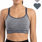 Woman wearing a gray sports bra with navy straps, featuring the brand 'Flex'.