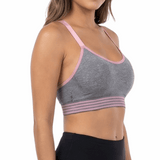 Woman wearing a gray sports bra and black leggings on a white background