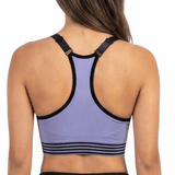 Woman wearing a purple sports bra and black leggings on a white background