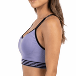Woman wearing a purple sports bra and black leggings on a white background