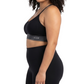 Woman wearing a black sports bra and leggings on a white background
