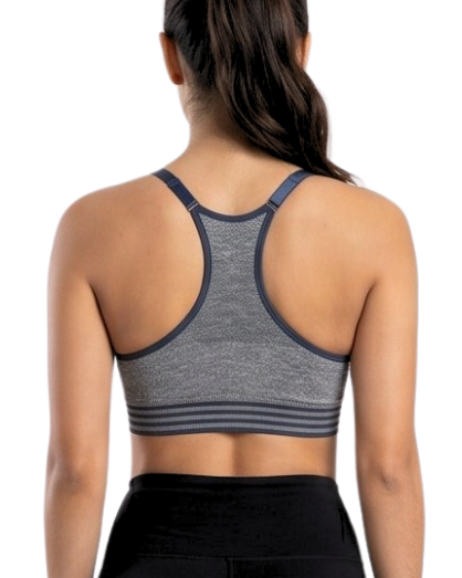 Woman wearing a gray sports bra and black leggings on a white background