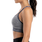 Woman wearing a gray sports bra and black leggings on a white background