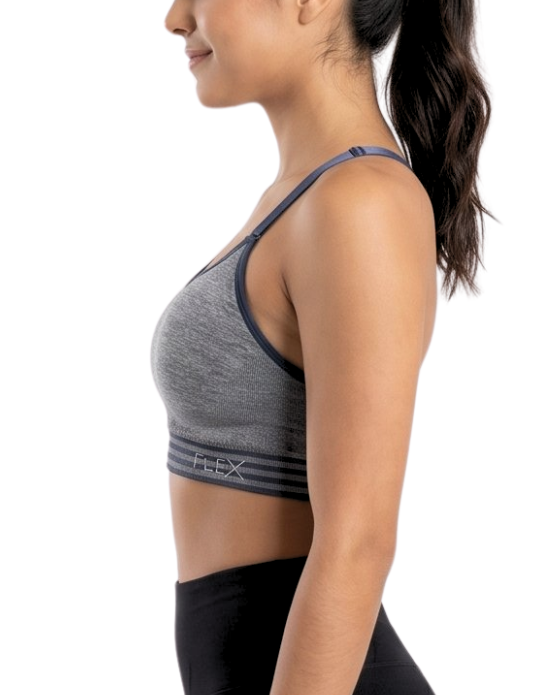 Woman wearing a gray sports bra and black leggings on a white background