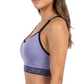 Woman wearing a purple sports bra and black leggings on a white background