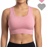 Woman wearing a pink sports bra with heart icons on a white background