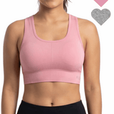 Woman wearing a pink sports bra with heart icons on a white background