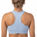 Person wearing a light blue sports bra and black leggings on a white background