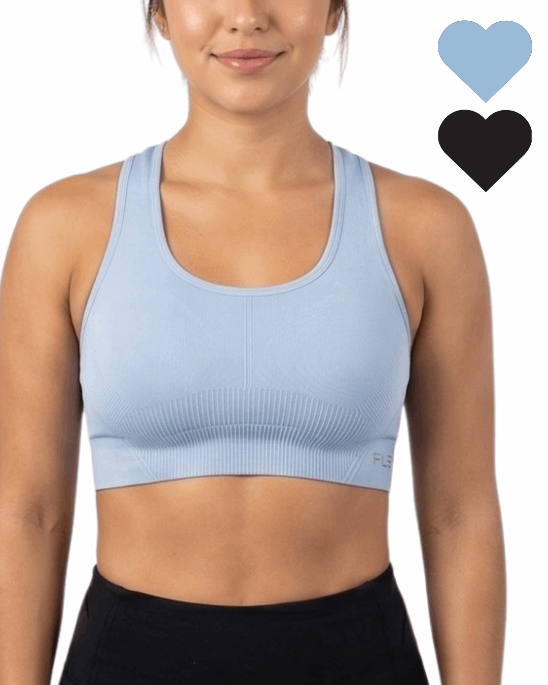 Woman wearing a light blue sports bra with black hearts on a white background