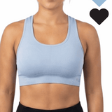 Woman wearing a light blue sports bra with black hearts on a white background