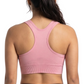 Woman wearing a pink sports bra and black leggings on a white background