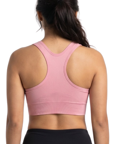 Woman wearing a pink sports bra and black leggings on a white background