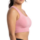 Woman wearing a pink sports bra and black leggings on a white background