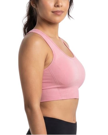 Woman wearing a pink sports bra and black leggings on a white background