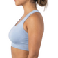 Woman wearing a light blue sports bra and black leggings on a white background