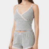 Woman wearing a gray lace-trimmed top and shorts set on a white background