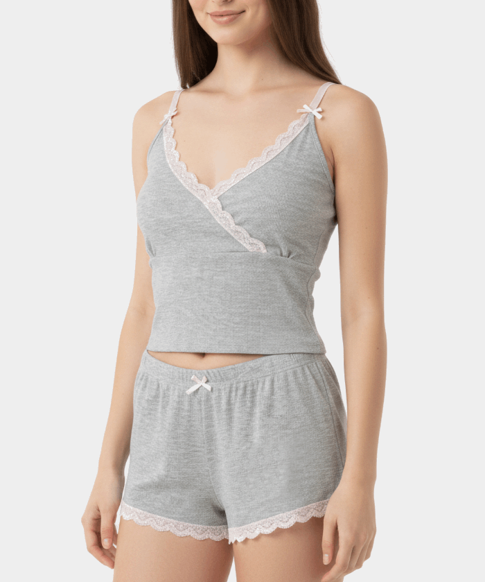 Woman wearing a gray lace-trimmed top and shorts set on a white background