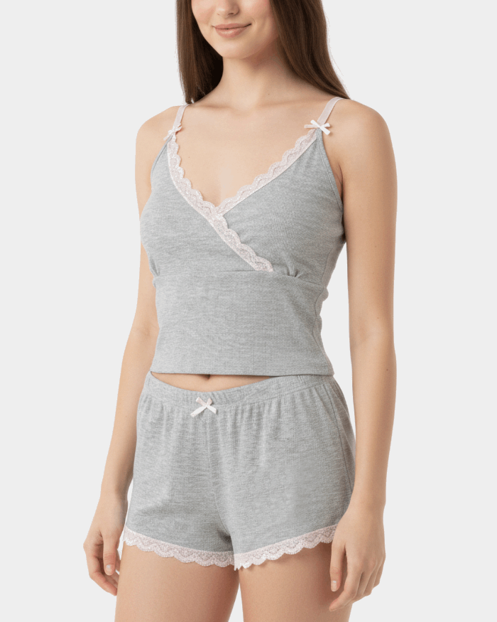 Woman wearing a gray lace-trimmed top and shorts set on a white background