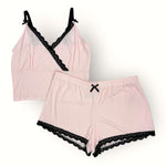 Pink lingerie set with black lace trim on a white background
