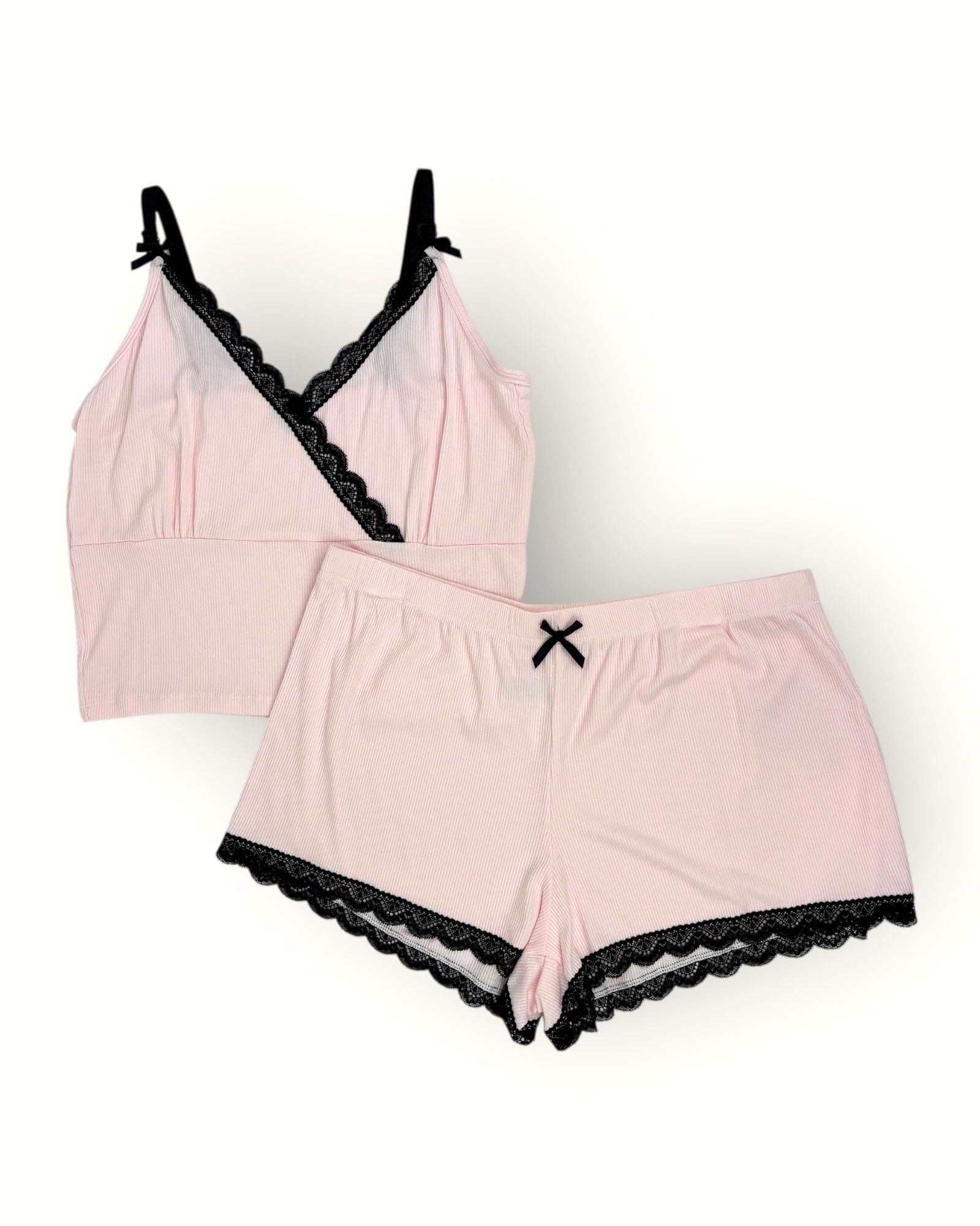 Pink lingerie set with black lace trim on a white background