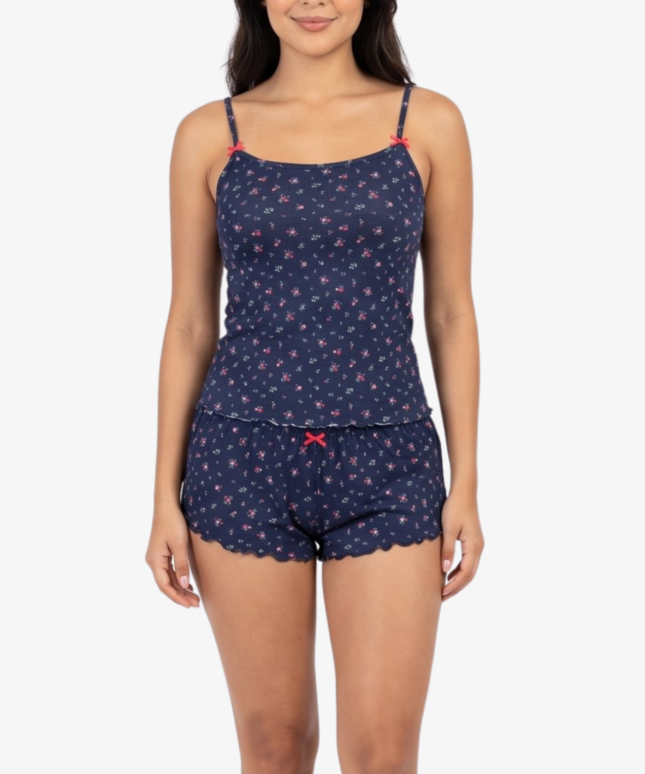 A woman modeling a navy blue two-piece pajama set with a small red and pink floral pattern, featuring a camisole top and matching shorts, against a plain white background.