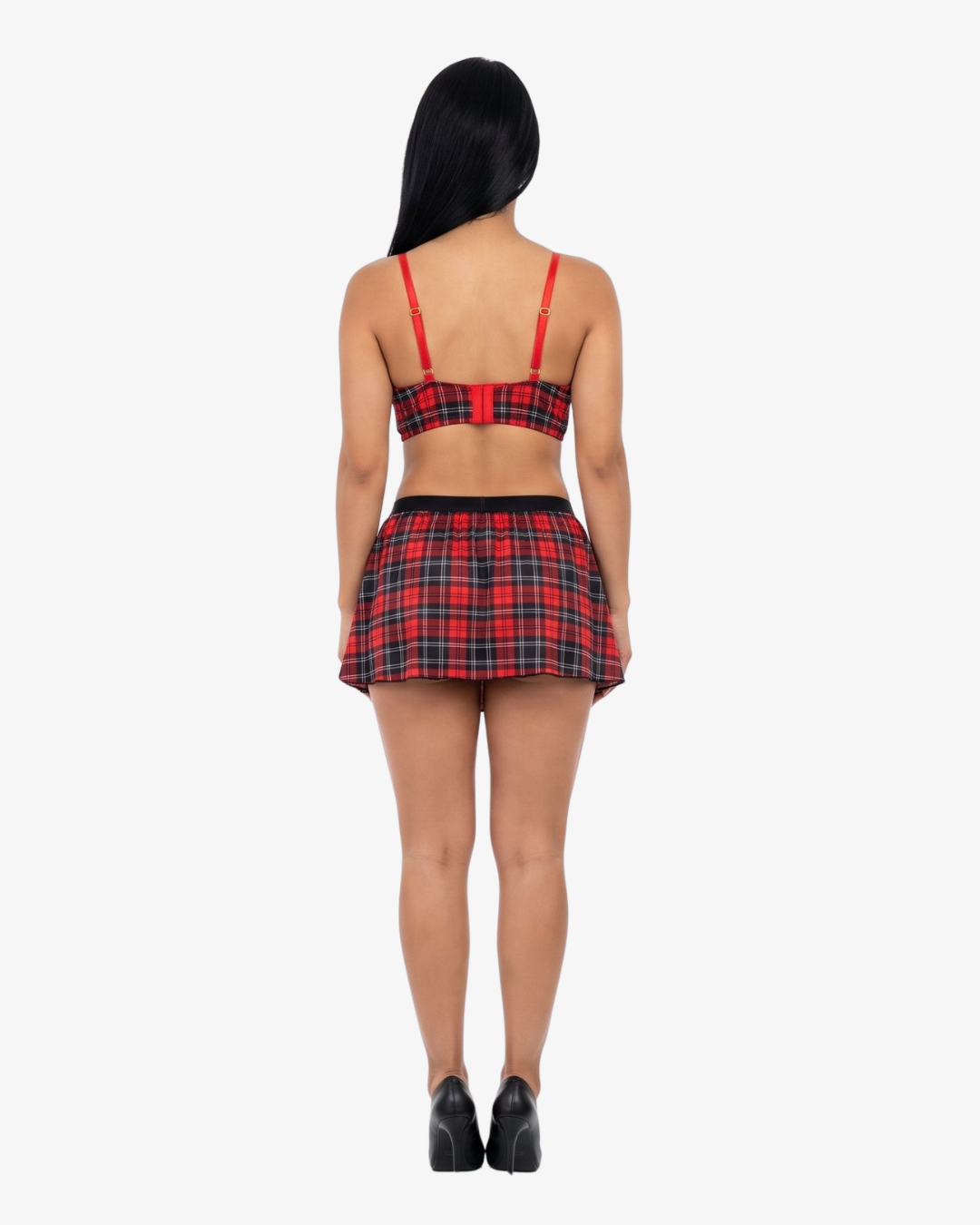 Woman wearing a red and black plaid top and skirt on a white background