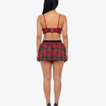 Woman wearing a red and black plaid top and skirt on a white background