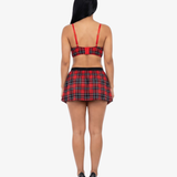 Woman wearing a red and black plaid top and skirt on a white background