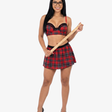 Woman wearing a red plaid outfit holding a wooden stick on a white background