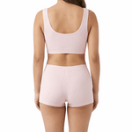 Woman wearing a pink sports bra and shorts set on a white background