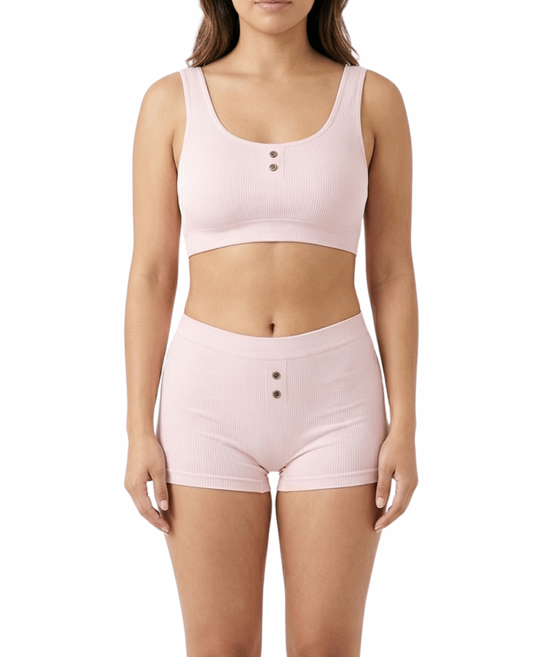 Woman wearing a pink comfort bra and shorts set on a white background