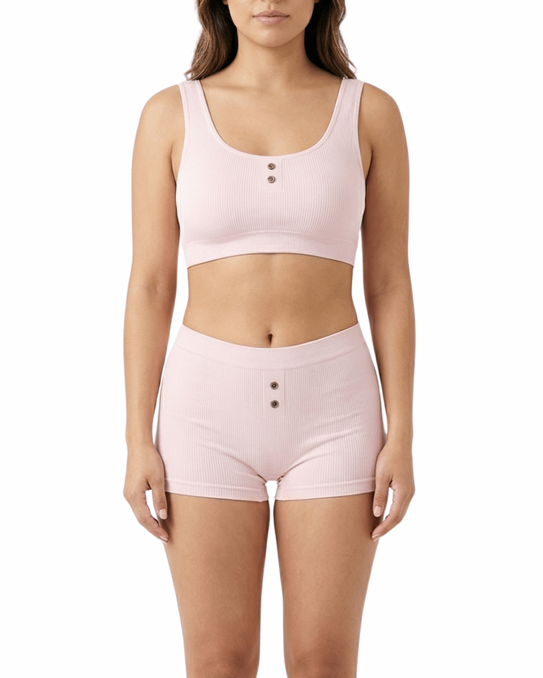 Woman wearing a pink comfort bra and shorts set on a white background