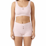 Woman wearing a pink comfort bra and shorts set on a white background