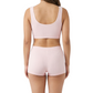Woman wearing a pink sports bra and shorts set on a white background