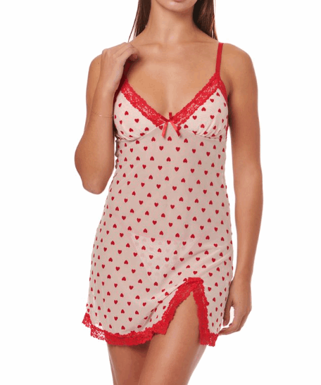 Woman wearing a red and white heart-patterned nightgown with lace trim on a white background