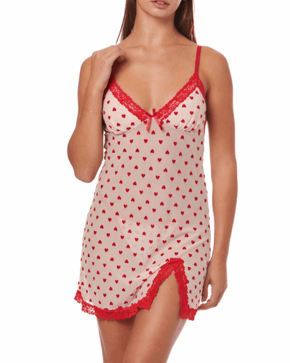 Woman wearing a red and white heart-patterned nightgown with lace trim on a white background