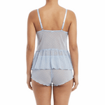 Woman wearing a light blue peplum top and matching shorts on a white background