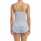 Woman wearing a light blue peplum top and matching shorts on a white background