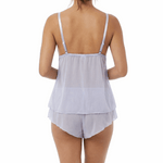 Woman wearing a light blue cami pajama set on a white background