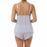 Woman wearing a light blue cami pajama set on a white background
