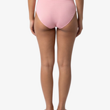 A woman modeling a light pink bikinis panty set against a plain light gray background.