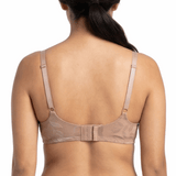 Woman wearing beige lingerie set on a white background