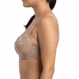 Woman wearing a beige lace bra and panties set on a white background