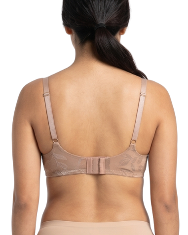 Woman wearing beige lingerie set on a white background