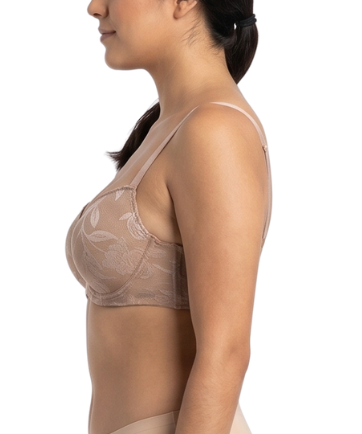 Woman wearing a beige lace bra and panties set on a white background
