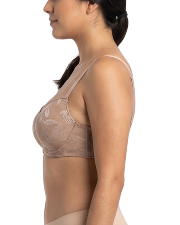 Woman wearing a beige lace bra and panties set on a white background