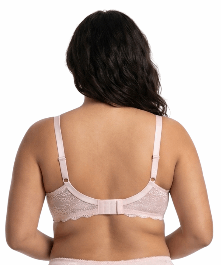 Woman wearing light pink comfort bra in a white background.