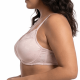 Woman wearing light pink comfort bra in a white background.
